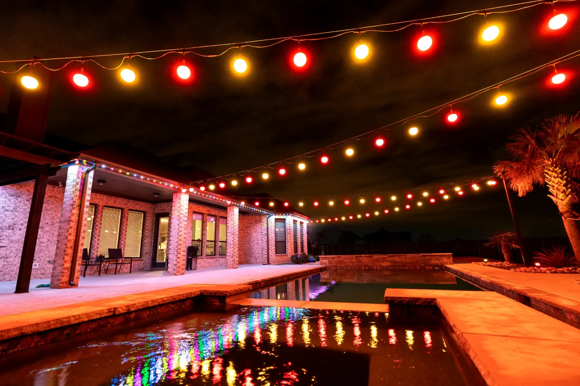 Patio lights over a pool and back porch